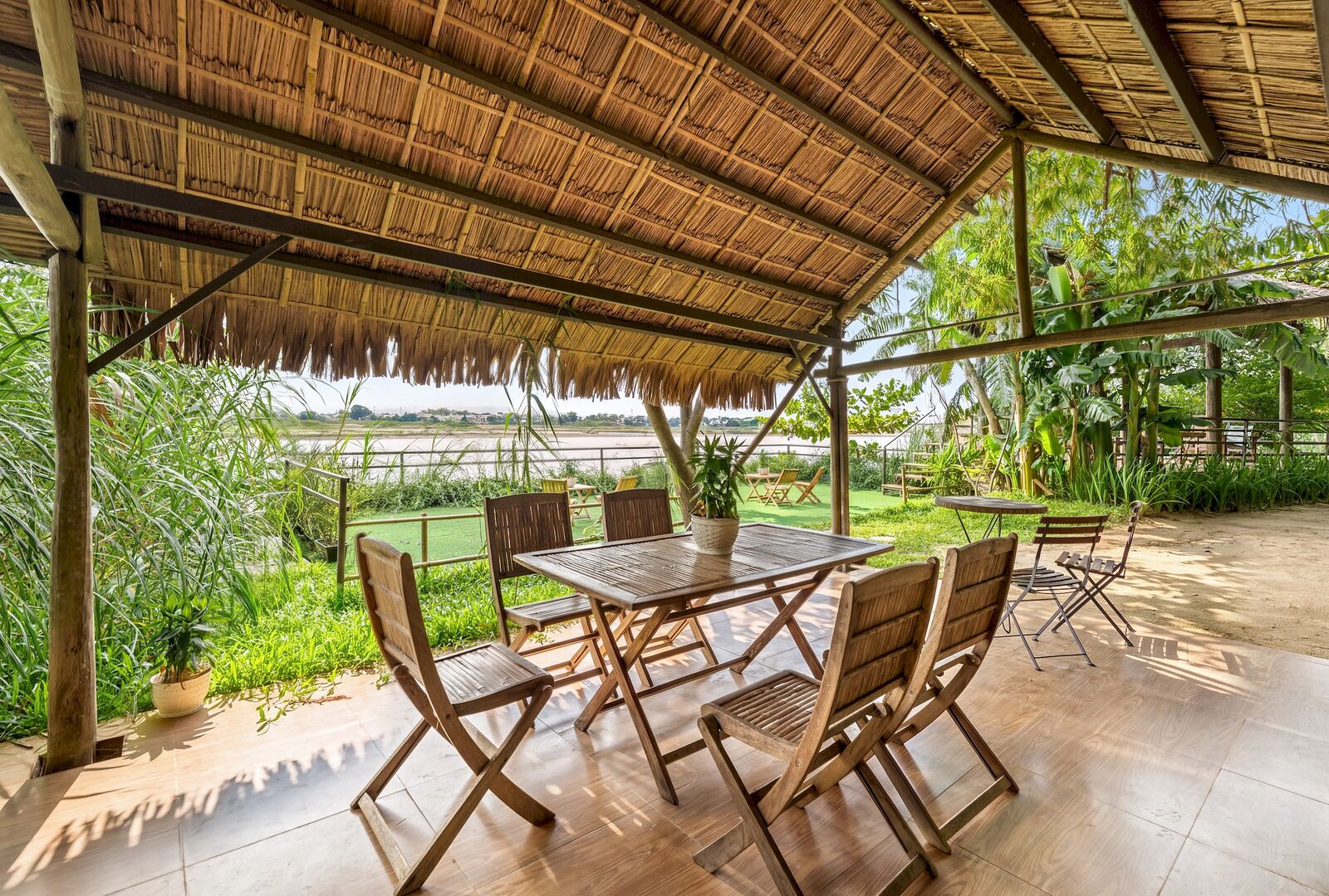 Thatched terrace with tables above the rice paddy