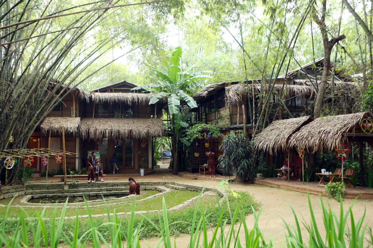 Village courtyard in our Vietnamese eco-village — bamboo, thatched roofs and community life